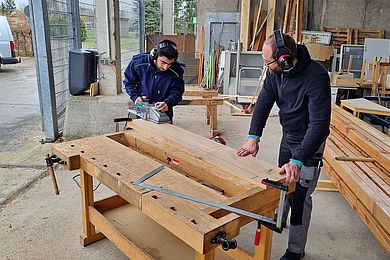 Teilnehmer und Werkstattpädagoge arbeiten in der Holzwerkstatt