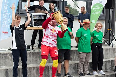 RB-Maskottchen Bulli beim Inklusionssportfest. Bulli hält einen Pokal in die Luft