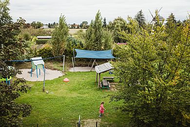 Blick auf den Garten mit Spielgeräten der Kinderwohngruppe