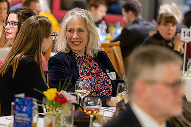 Christina März und Katharina Krefft im Gespräch miteinander. Katharina Krefft trägt eine geblümte Bluse und einen dunkelblauen Samtblazer. 