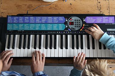 Zwei Kinder spielen Keyboard