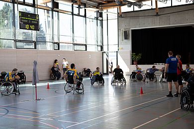 Einige Rollstuhlfahrer versammeln sich in der Turnhalle zum Rugbyspiel.