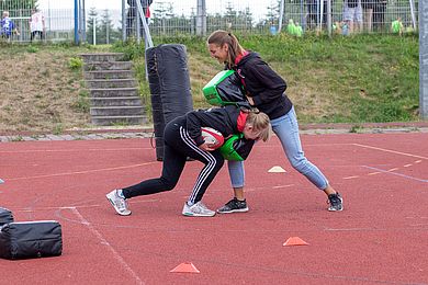 Zwei Personen probieren Rugby aus